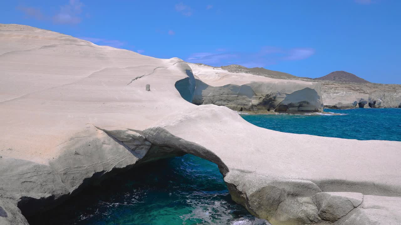 希腊米洛斯希腊岛Sarakiniko海滩沿岸火山岩拱形构造的视差跟踪视频素材