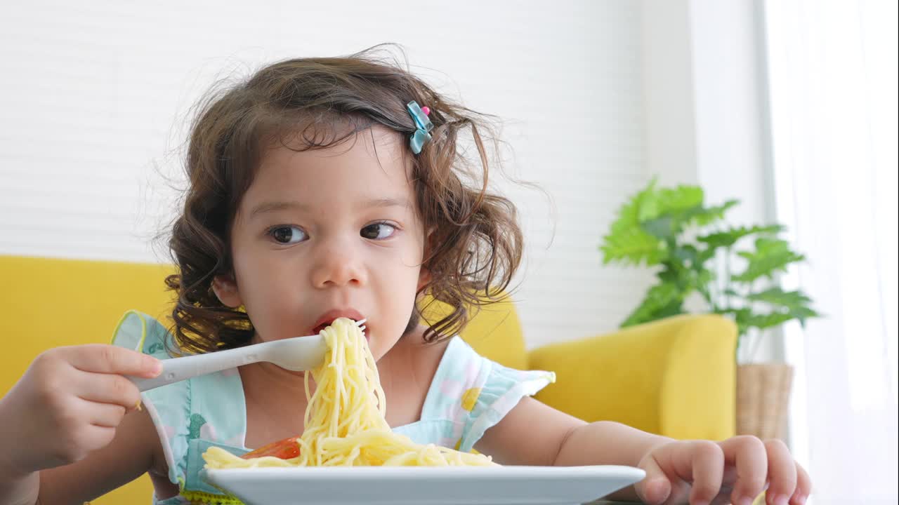 小女孩在桌子上吃意大利面视频素材