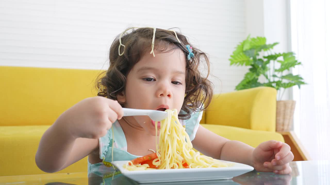 小女孩在桌子上吃意大利面视频素材