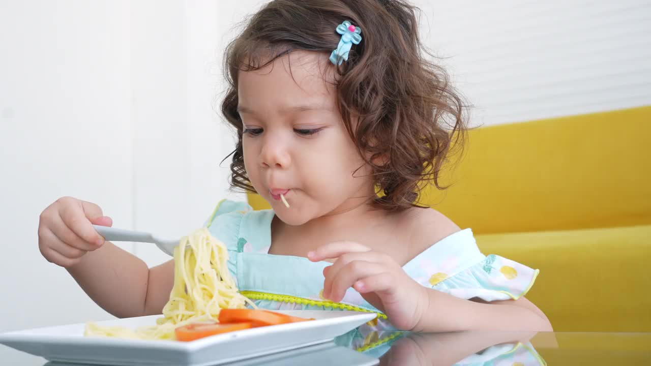 小女孩在桌子上吃意大利面视频素材