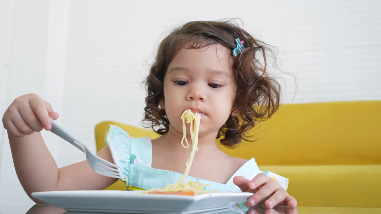 小女孩在桌子上吃意大利面视频素材