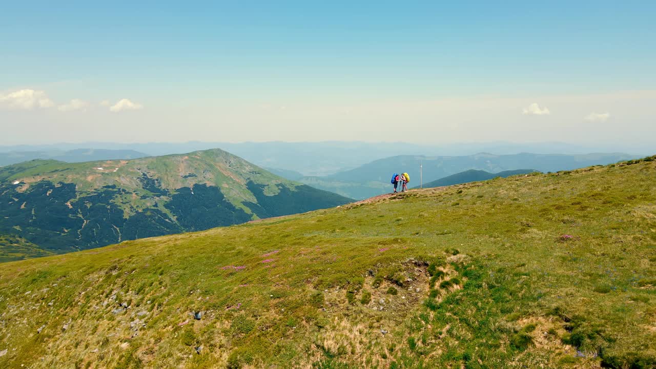 两名游客站在黑山山脊上。鸟瞰图游客攀登到山顶上的天文台和观察点。到山顶的旅程视频素材