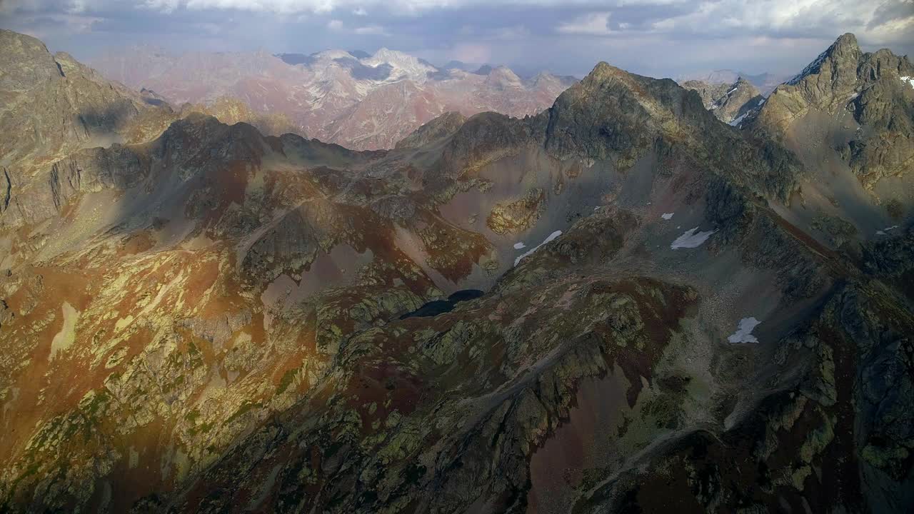 鸟瞰图的一个小山湖。山谷中清晰的云影。高山上原封未动的大自然。冰川湖。湖的四周是悬崖峭壁。色彩斑斓的森林在群山中一个清澈的山湖周围闪耀着橘黄色的光芒。视频素材