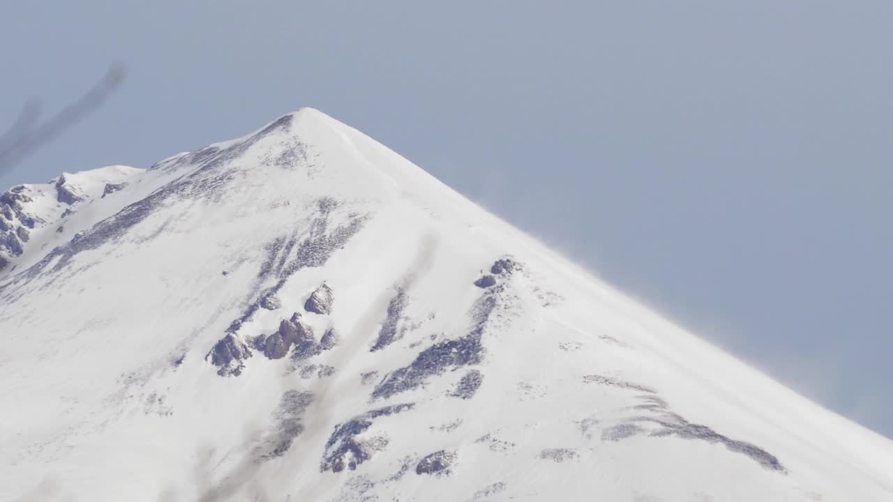 在阿尔卑斯山脉的暴风雪期间，山顶山坡上飘雪视频素材