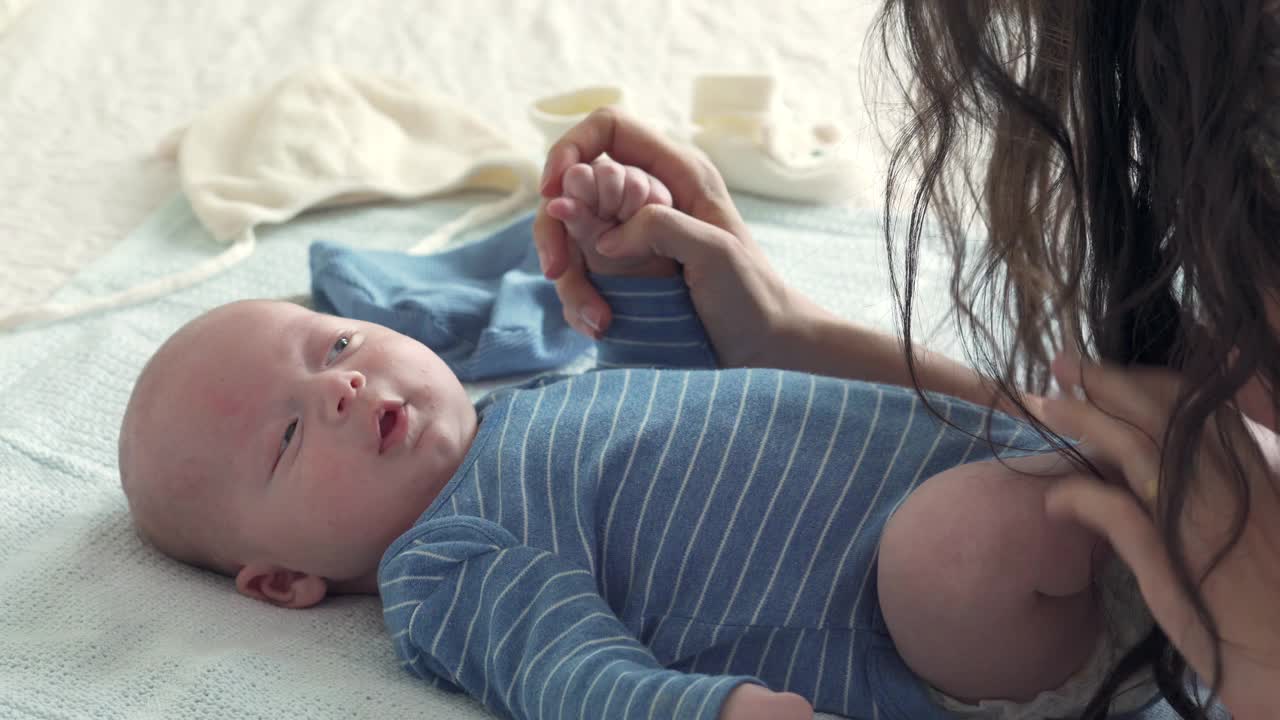 快乐的白种人妈妈和刚出生的小男孩在床上玩耍视频素材