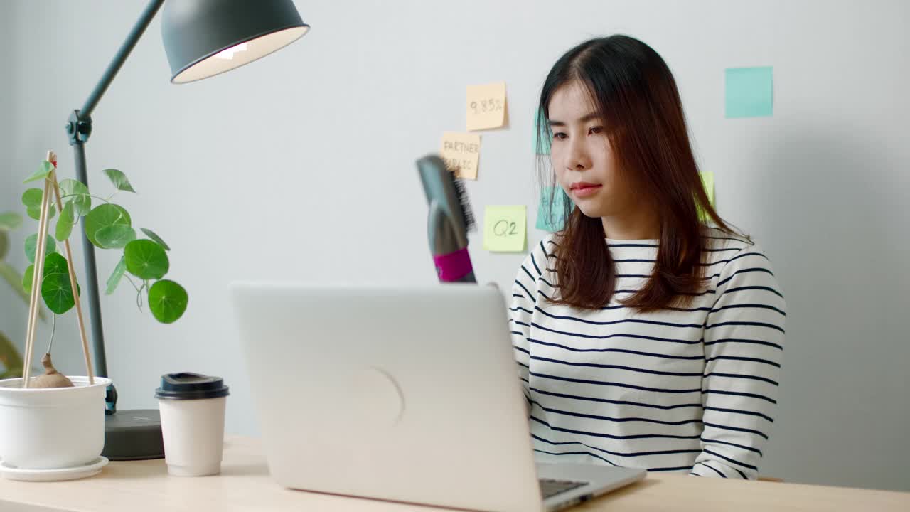 一位女士正在用吹风机梳头发视频素材