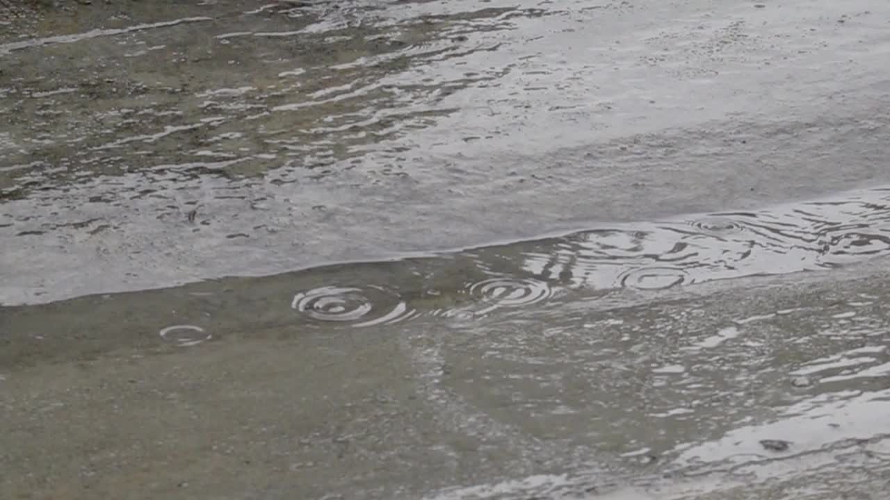 雨落在人行道上的慢动作。视频素材