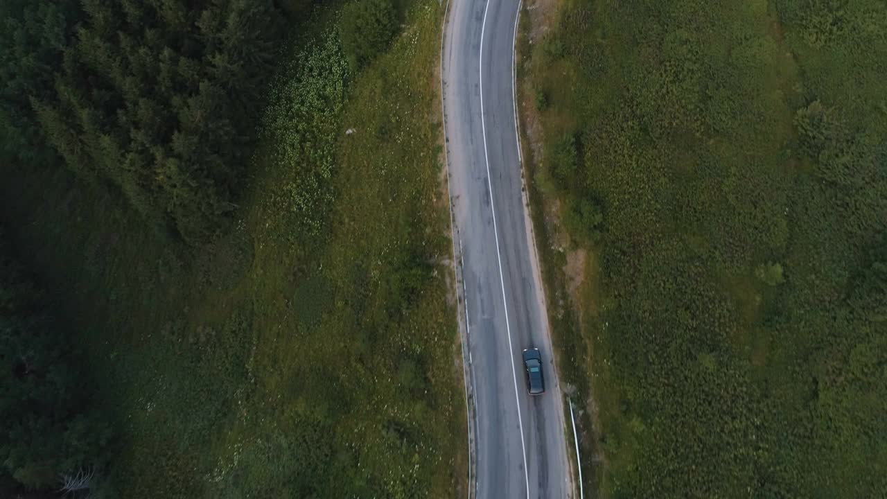 一辆黑色轿车在森林山路上行驶视频素材