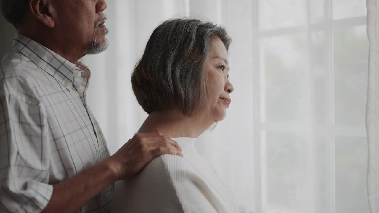 老夫妇安慰看着窗外沮丧的女人视频素材