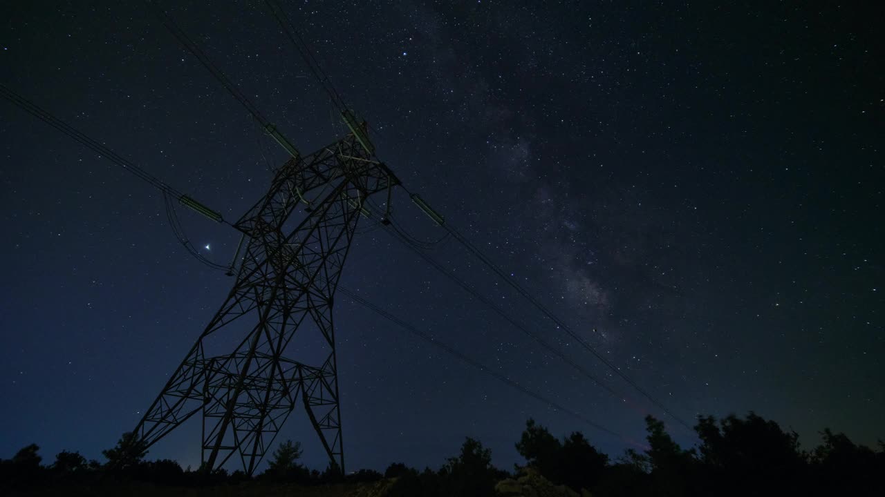 电力线塔顶着繁星点点的夜空视频素材