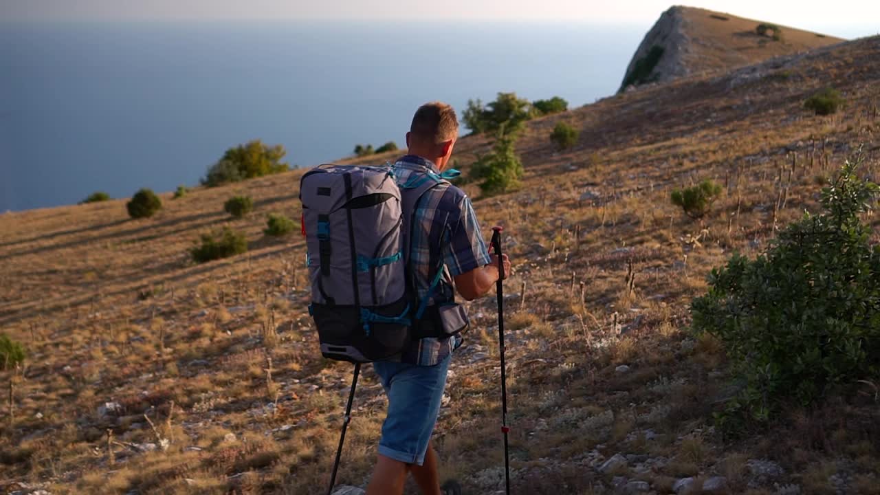 旅行登山回望男性徒步旅行者正在沿着岩石地区行走在一个秋天的天SPBD视频素材