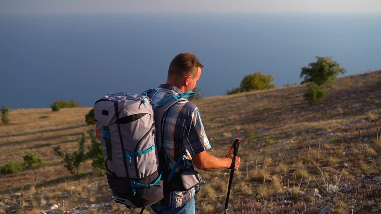 徒步旅行者旅行去探索海边的岩石。游客户外攀爬。徒步旅行视频素材