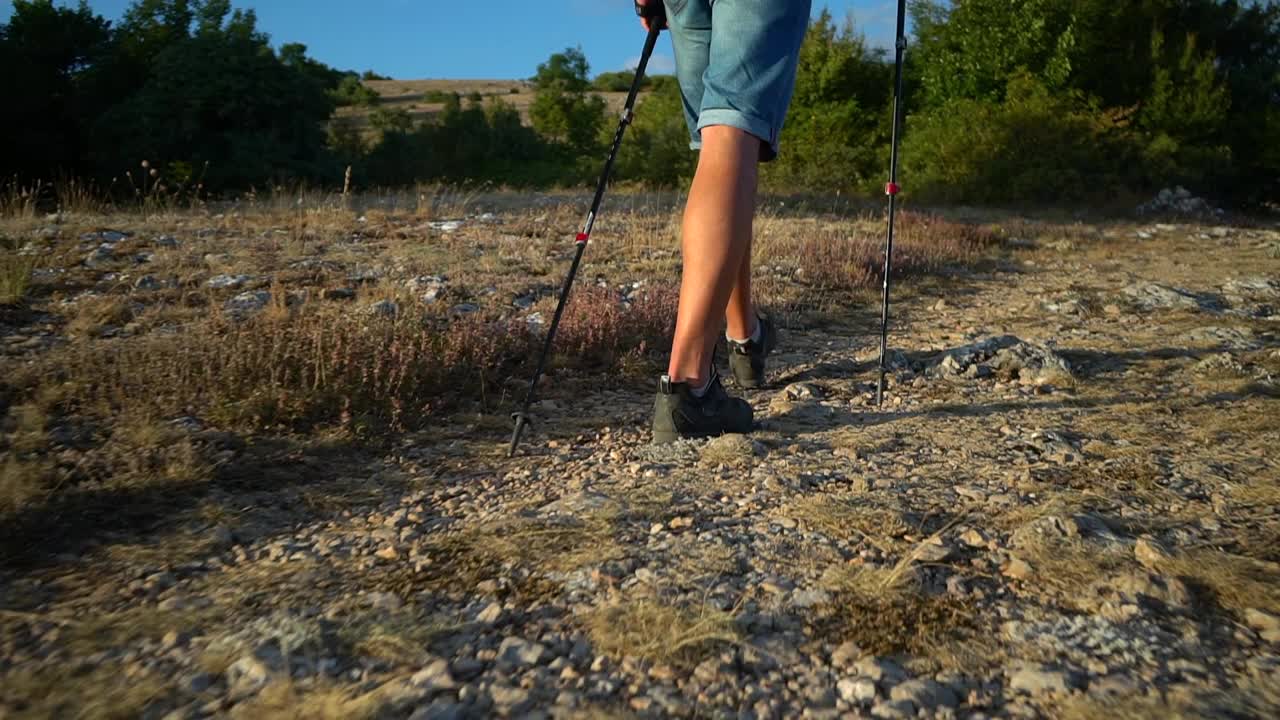 男徒步者的背影，在夏日的阳光下，正沿着岩石地带微笑视频素材