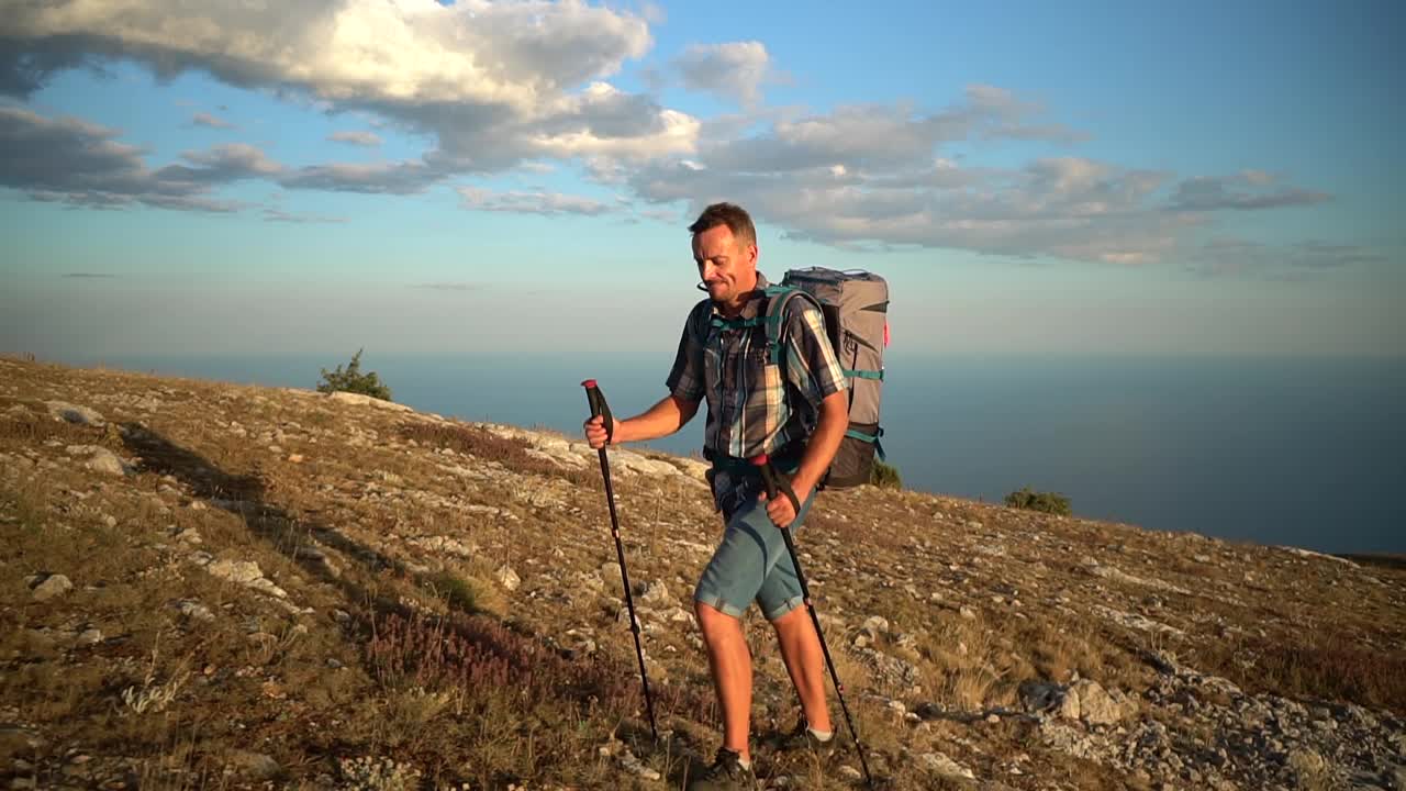 登山徒步旅行愉快的微笑的登山运动员登山徒步旅行在夕阳中旅行克里米亚徒步旅行者享受小径视频素材