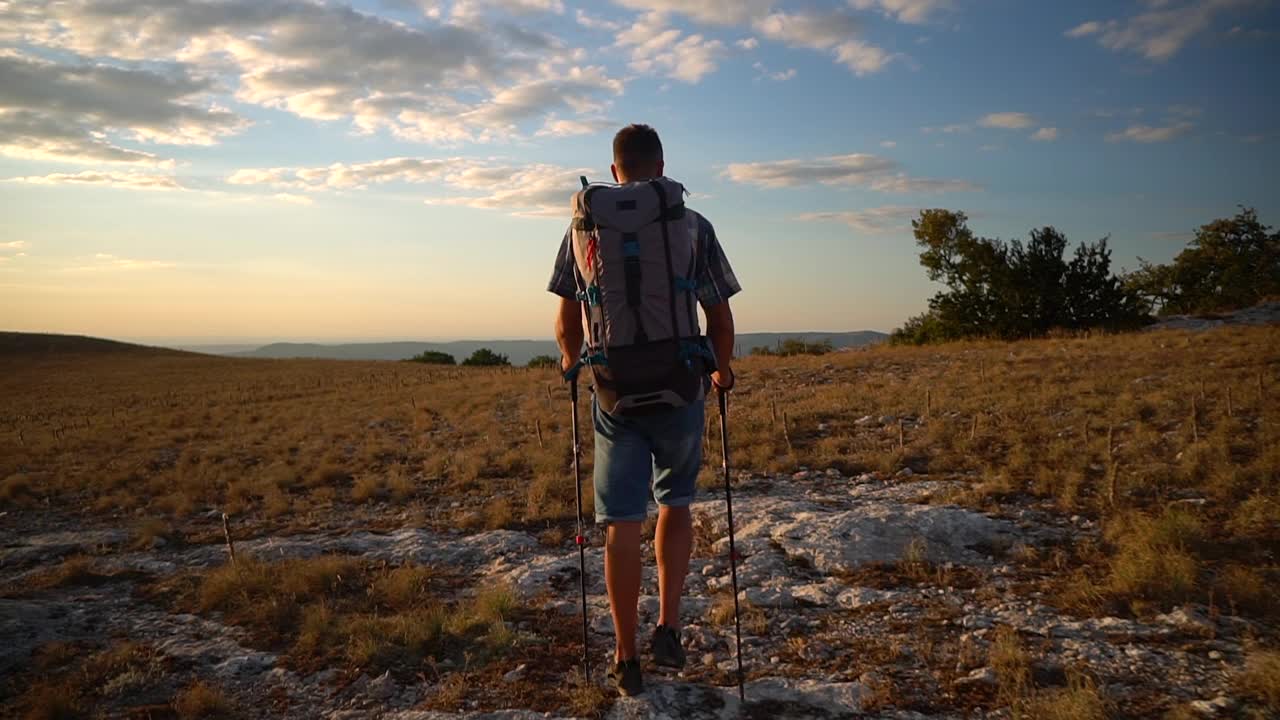 旅行登山后视图年轻的男性徒步旅行者正在沿着岩石地区在秋天天SPBD视频素材