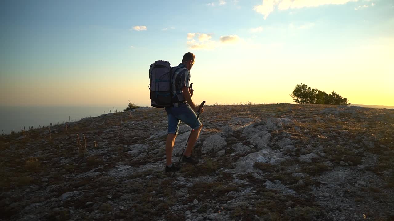 一名年轻的男性旅行者在秋日的岩石地区徒步旅行，欣赏着美丽的风景视频素材