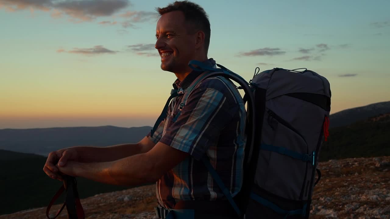 高兴兴奋的男子举起手和登山杆在徒步旅行在日落黎明Spbd。肖像视频素材