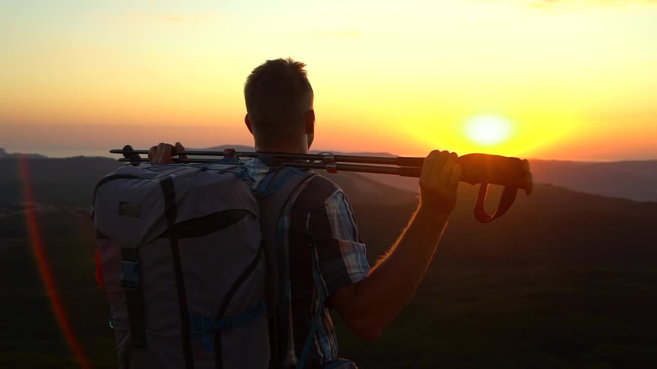 man hiker的后视图站在登山旅行高峰和看日落Spbd。旅游穿的背包视频素材