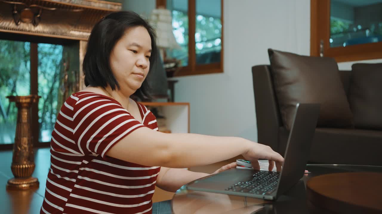 女性测量血氧水平与脉搏血氧计，同时视频电话与医生在家里。视频素材