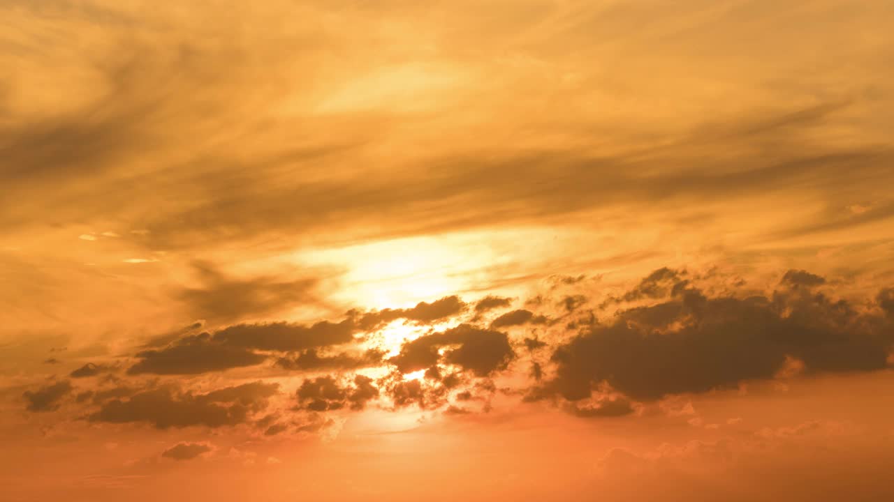 天空和晚霞都是橘黄色的。太阳落在云后面了。视频素材