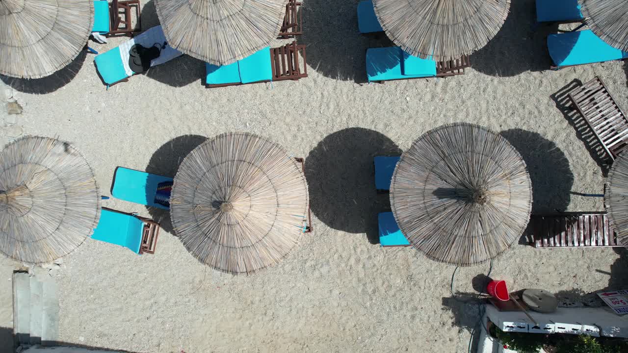 鸟瞰图的太阳伞和躺椅站在海滩上视频素材