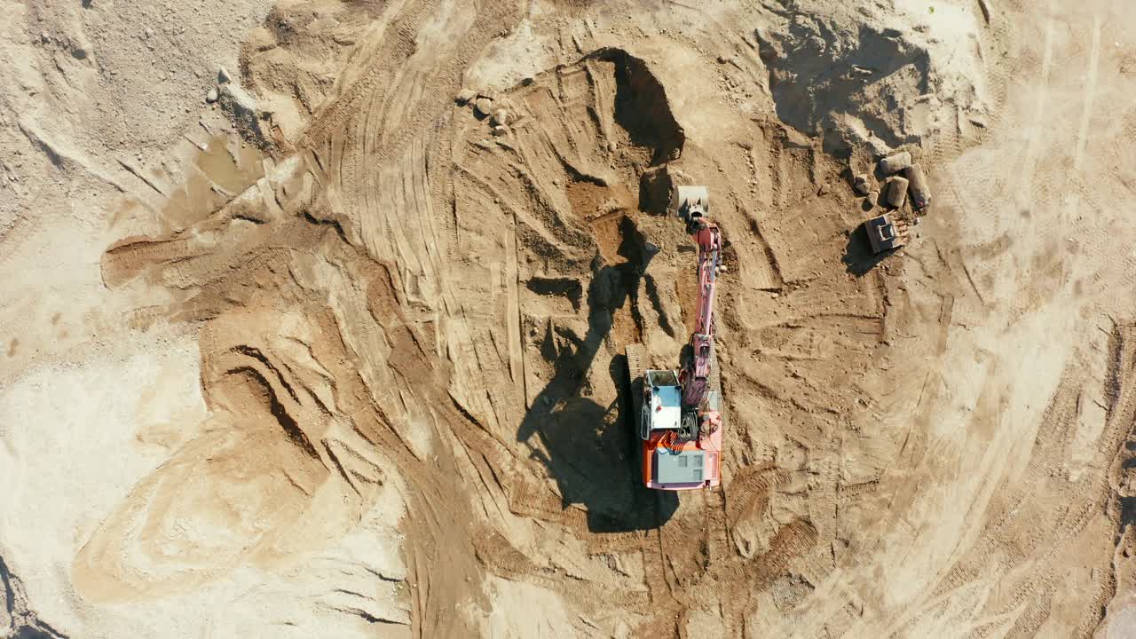 挖掘机带着施工现场的泥土上山，清理地面，为建筑施工做好场地准备。挖掘机司机从驾驶室里出来视频素材