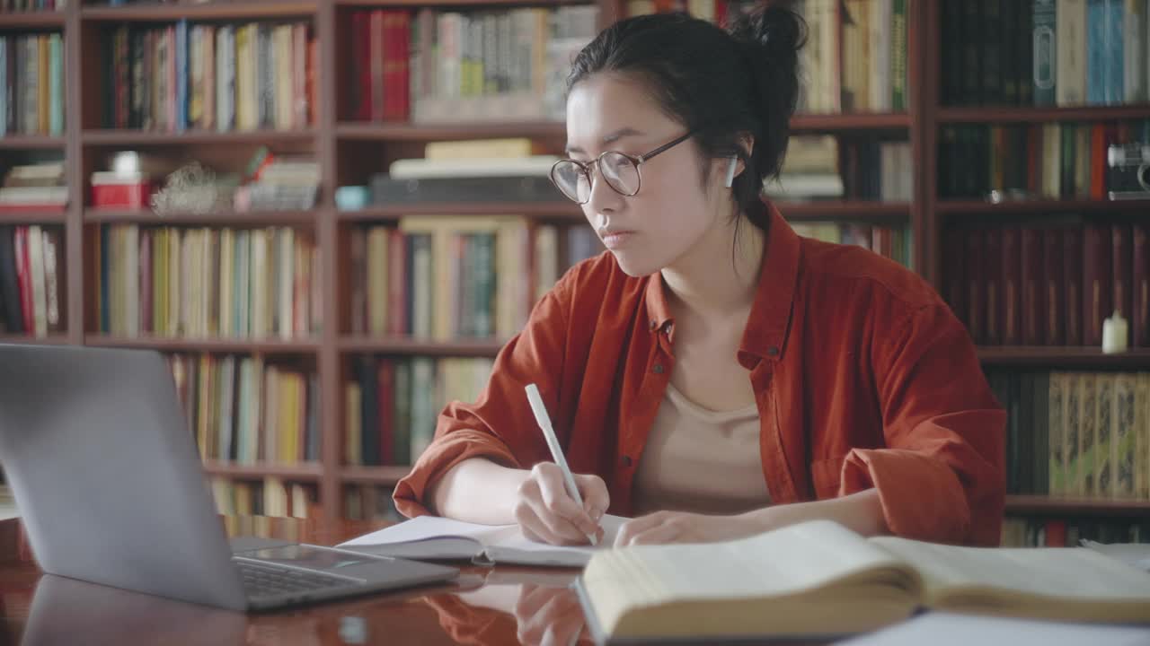困倦疲倦的亚洲学生做笔记从在线课程，远程教育视频下载