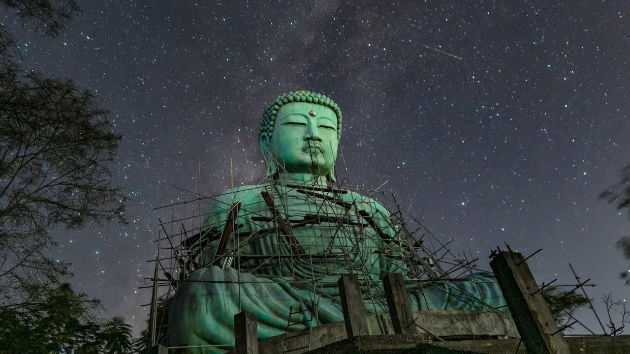 “大佛”(Daibutsu)在银河背景的铜像Doi Phra Chan在佛寺在泰国兰邦市Mae ta市。视频素材