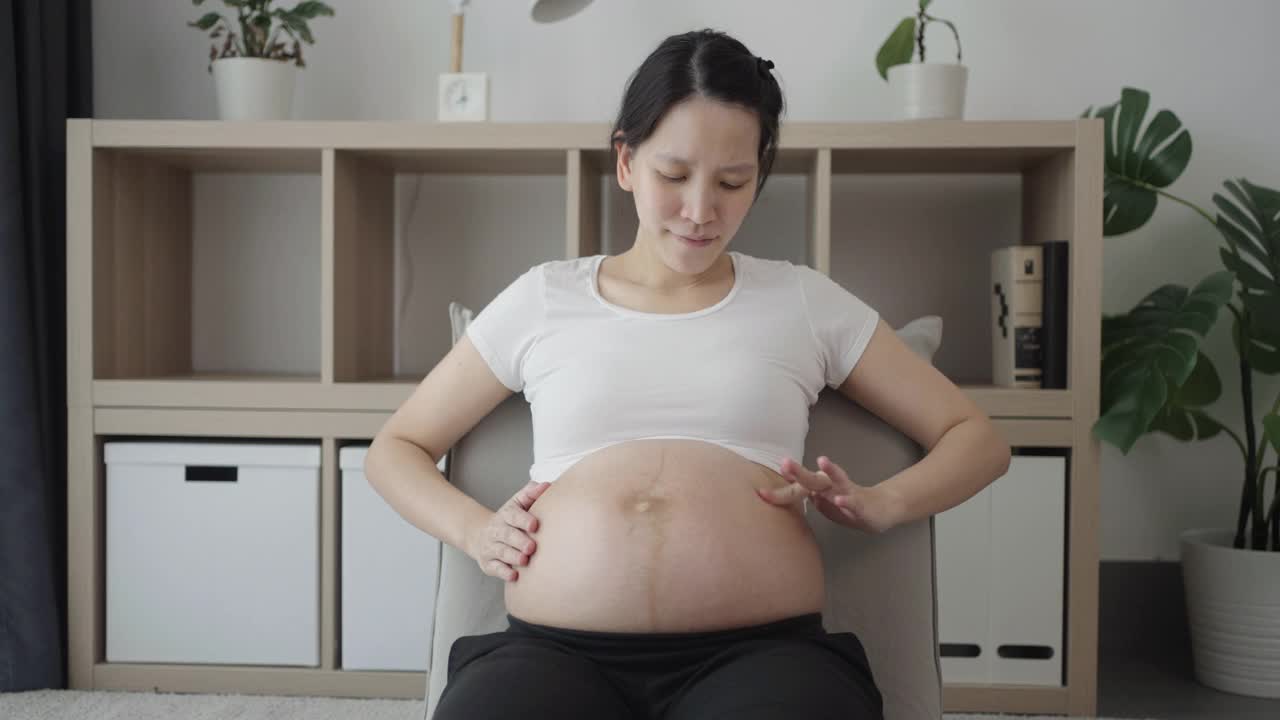 孕妇在家用面霜治疗腹部视频素材