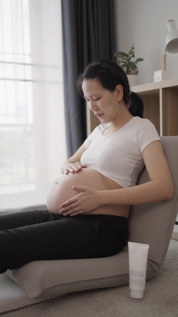 孕妇在家用面霜治疗腹部视频素材