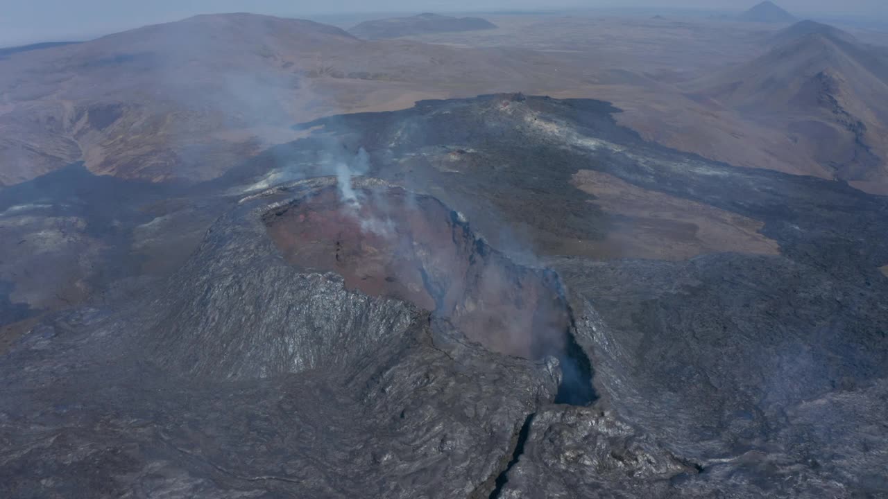 无人机在法格拉达斯火山上空向后飞行，展现出冰岛壮观的熔岩景观视频素材