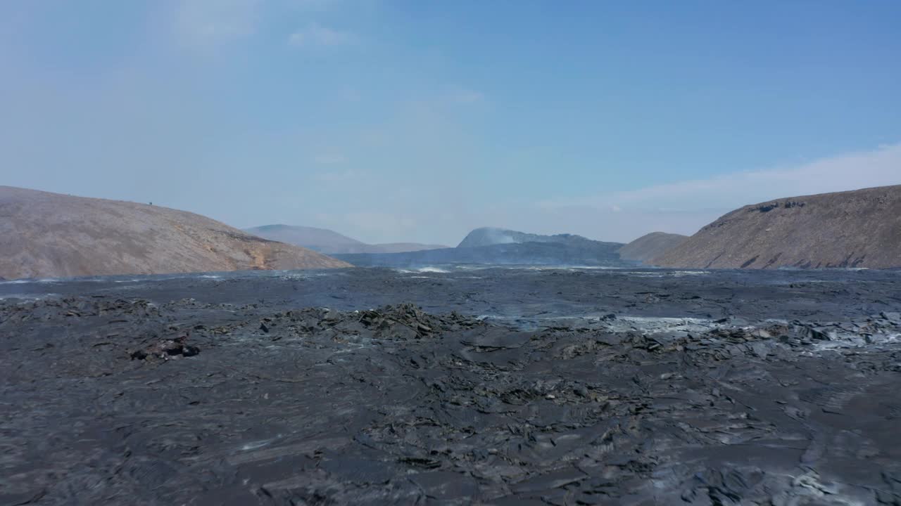 在冰岛fagradalsjall巨大的黑色熔岩湖上空，无人机低空飞行视频素材