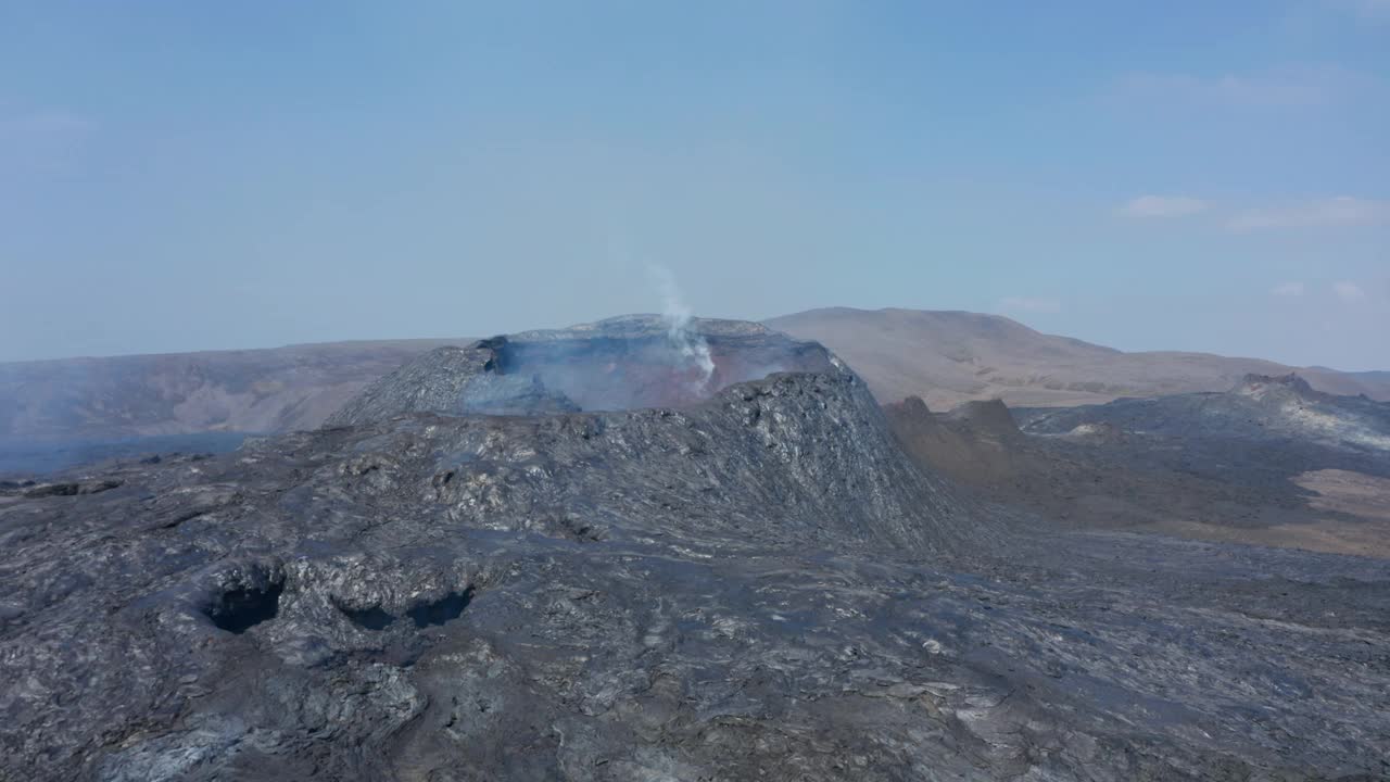 Fagradalsfjall火山，无人机飞向冒烟的裂缝锥，倾斜向下鸟瞰头顶上自上而下的视图揭示火山口，冰岛，白天视频素材