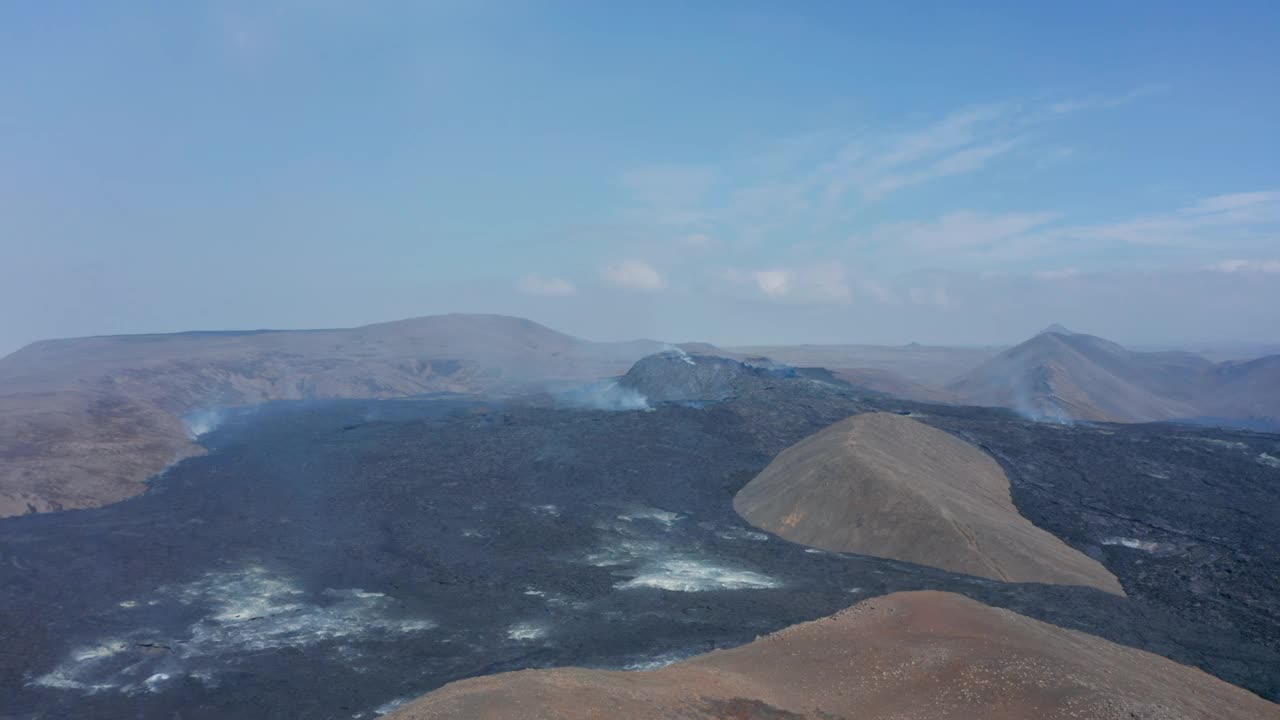 无人机拍摄的Fagradalsfjall火山，景观覆盖着黑色熔岩，无人机向前飞向烟雾锥，冰岛，白天视频素材