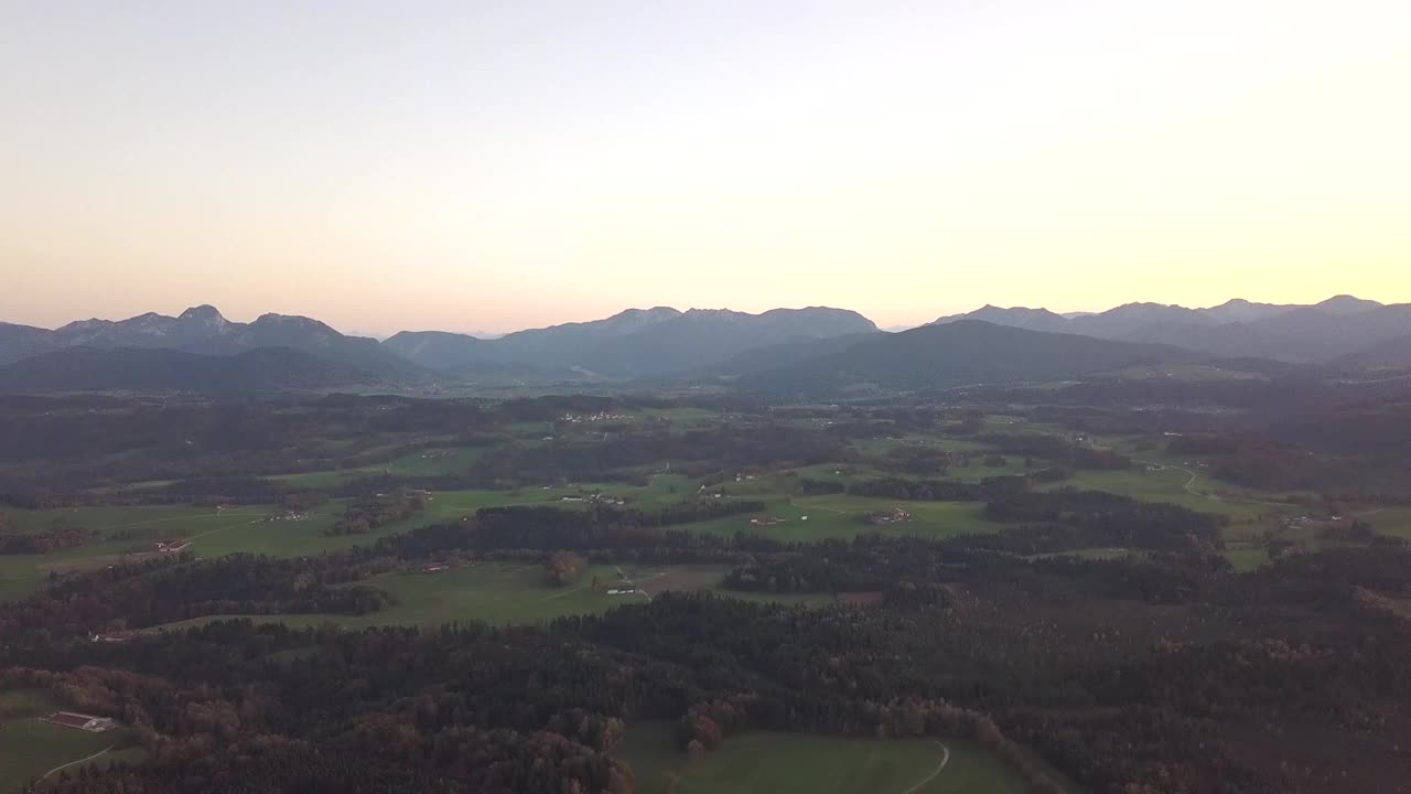 在奥地利阿尔卑斯山脉鸟瞰绿色草地与村庄和森林。视频素材