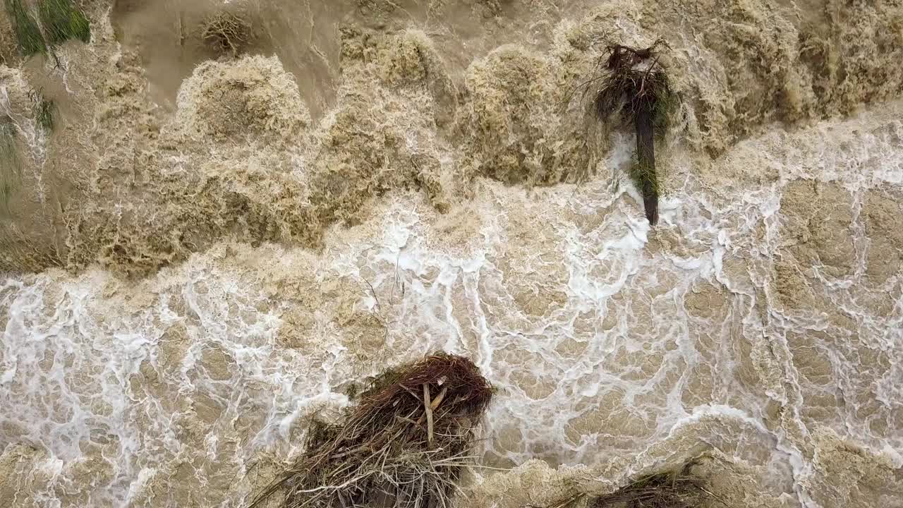 鸟瞰图宽阔的肮脏的河流与泥泞的水在洪水期间在暴雨的春天。视频素材