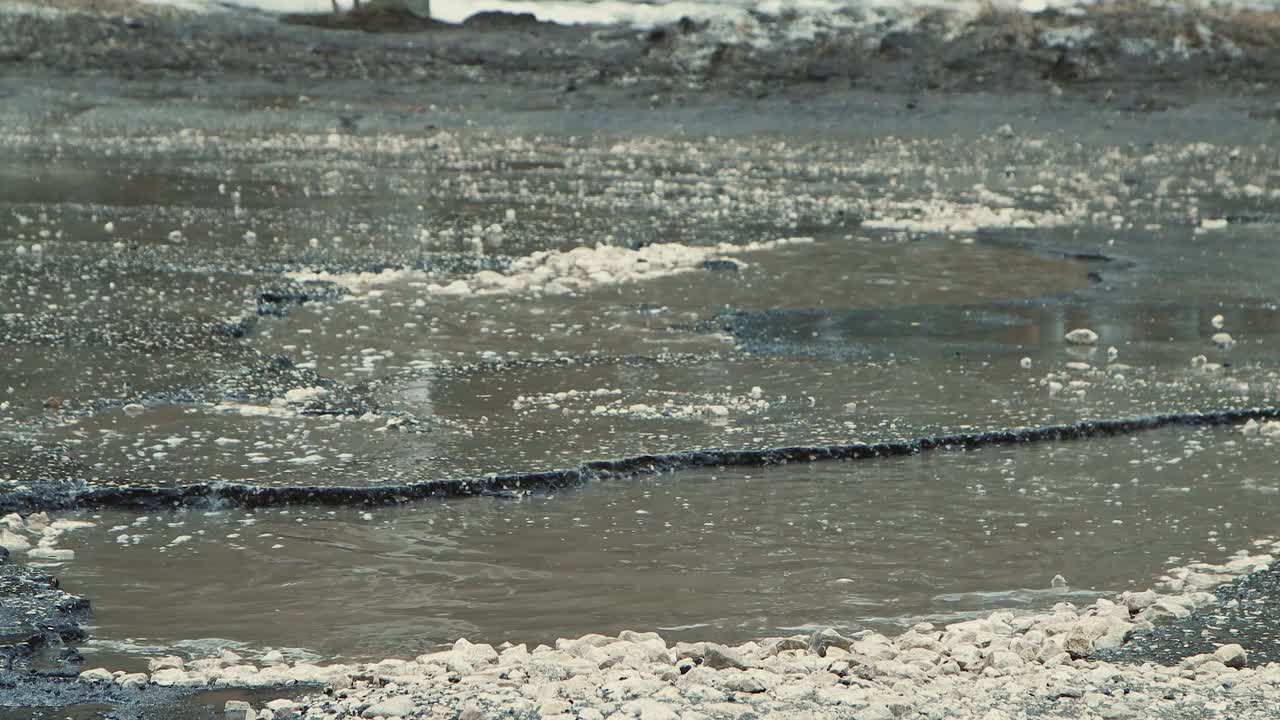 恶劣天气下的大坑积水严重破坏了道路基础设施。视频素材