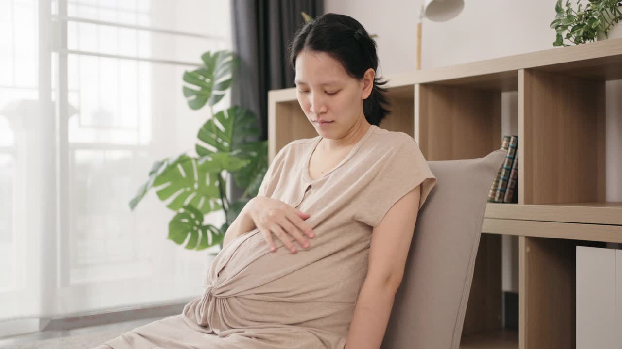 一名怀孕妇女在接种疫苗后向镜头展示她的手臂和微笑。视频素材