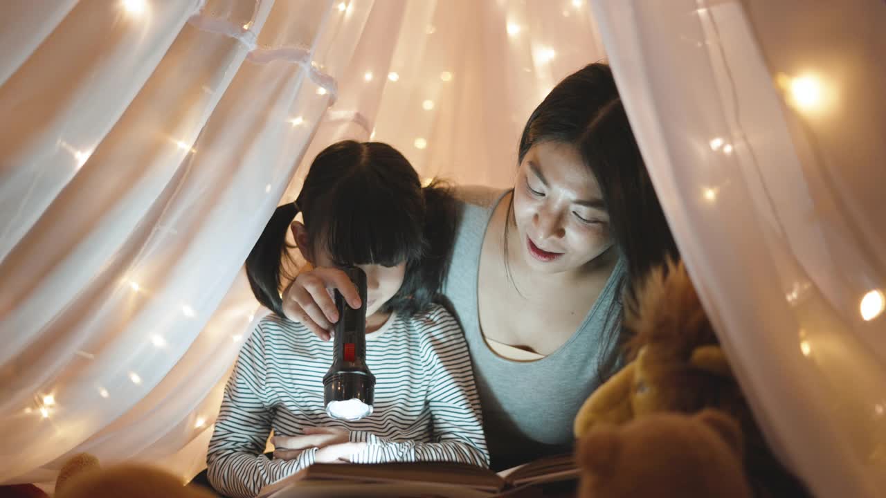 晚上，妈妈和女儿一起看野生动物图画书。视频下载