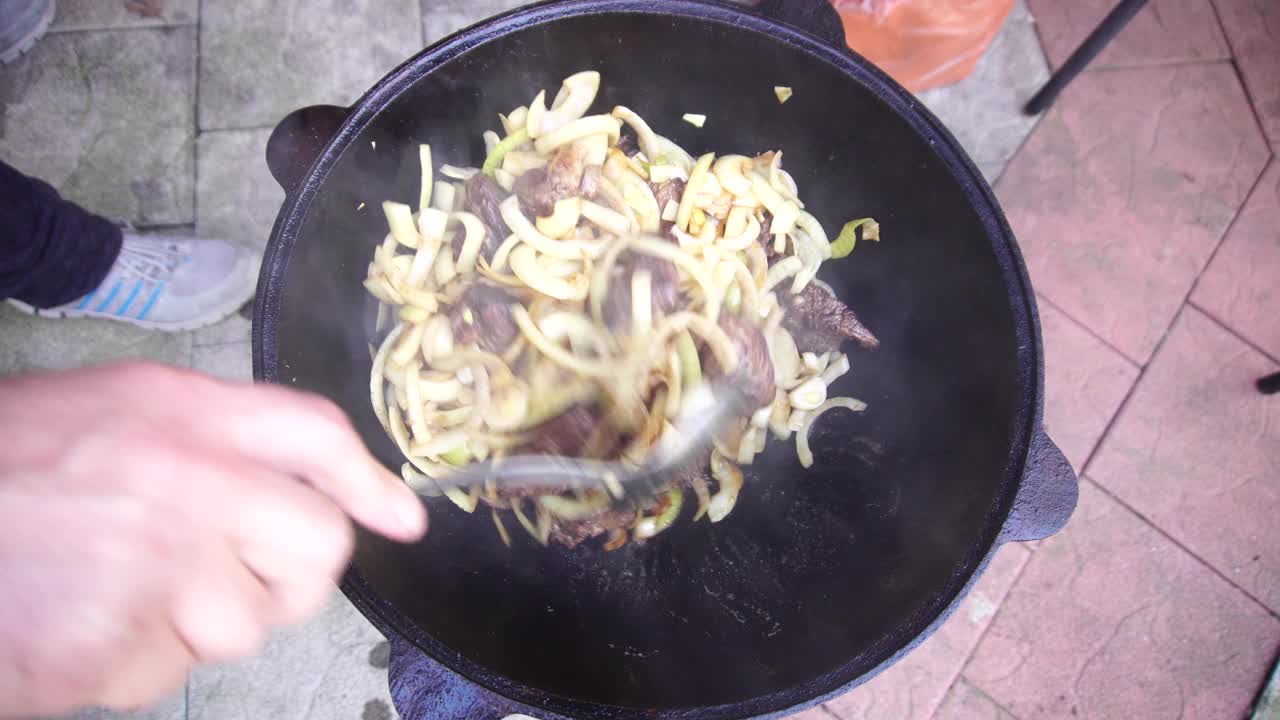 将肉、洋葱和大蒜在锅里搅拌，做成肉饭视频素材