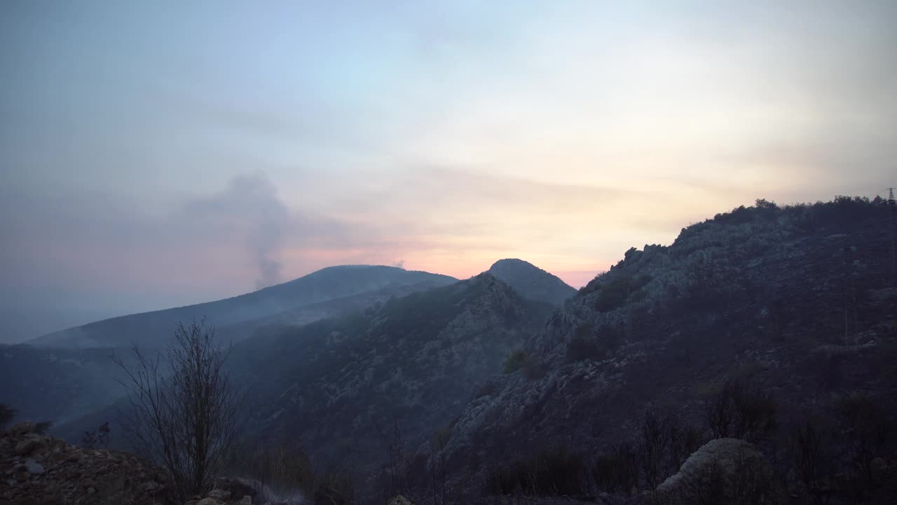 夕阳透过烟雾从山林大火视频素材