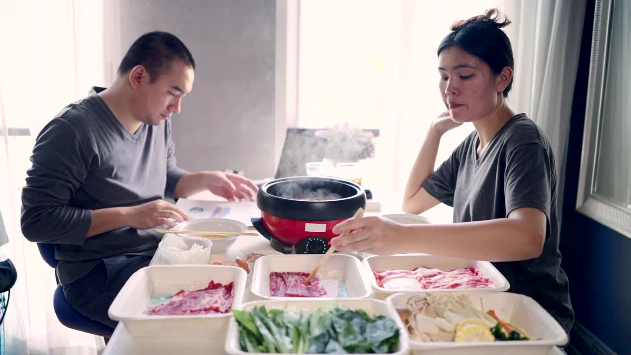 一对夫妇在吃午饭，她的丈夫在隔离期间在家工作。视频素材