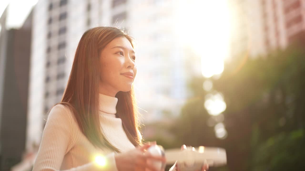 亚洲年轻女子在城市里听音乐视频素材