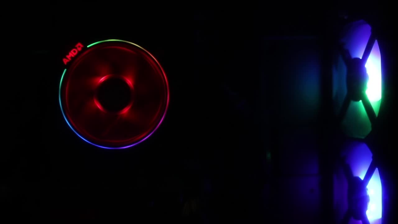 RGB PC旋转的冷却风扇与明亮的旋转上的黑色背景和多色RGB光与安全网。视频素材