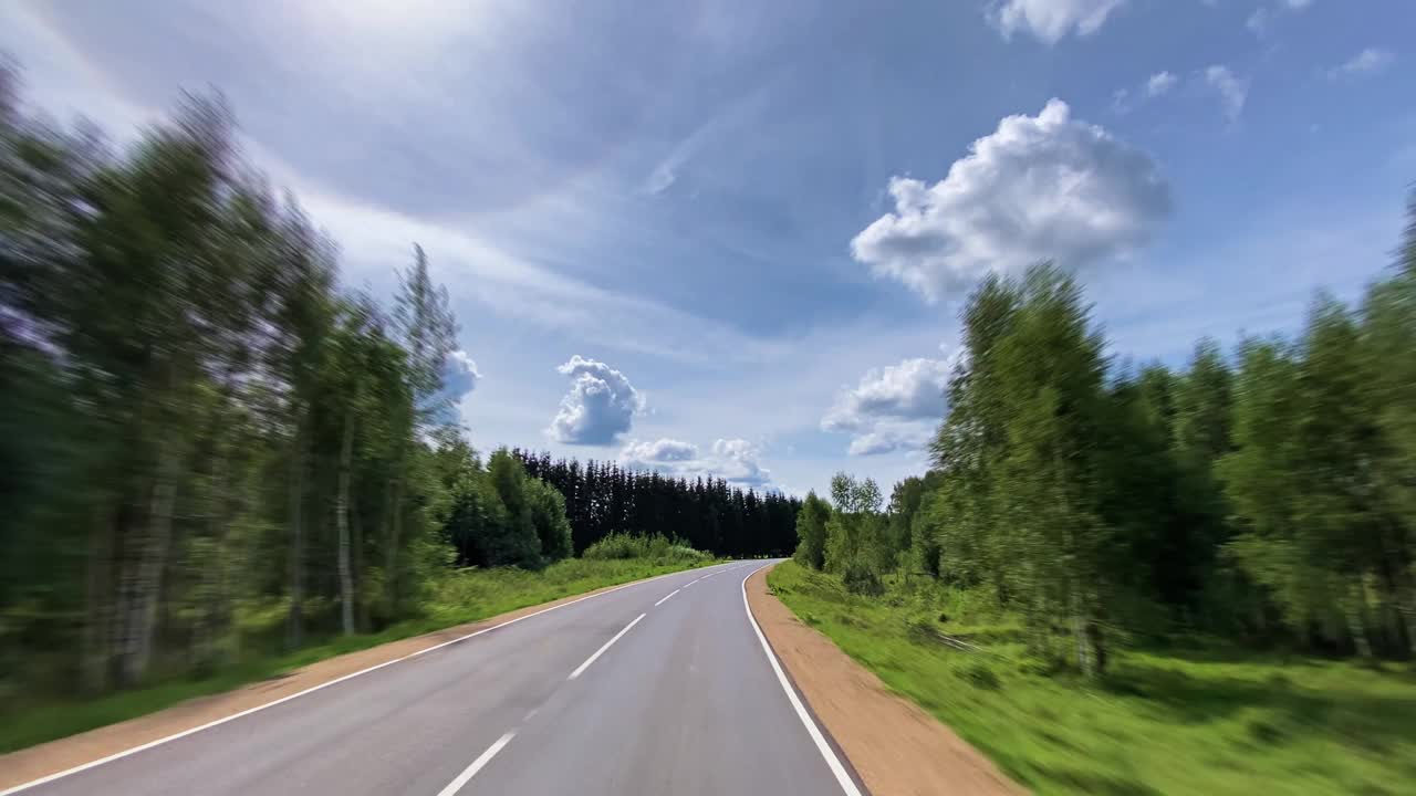 在穿过森林的乡间小路上开车视频素材