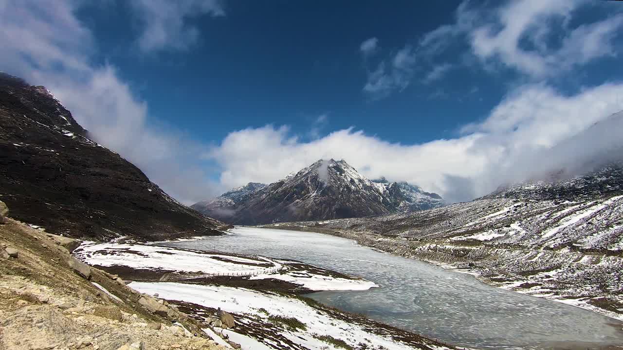 时间流逝的冰冻塞拉湖与雪冠山和明亮的蓝色天空在早晨从平面角度视频素材