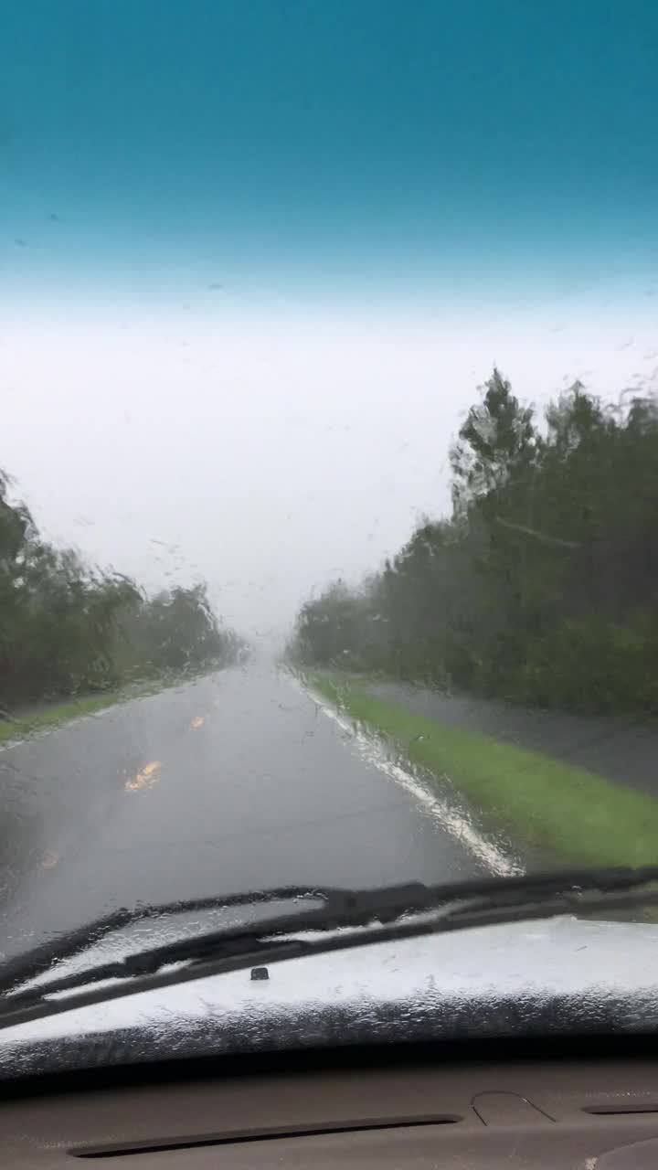 乡村森林道路上的司机视野，雨刷无法清除眩目的雨视频素材