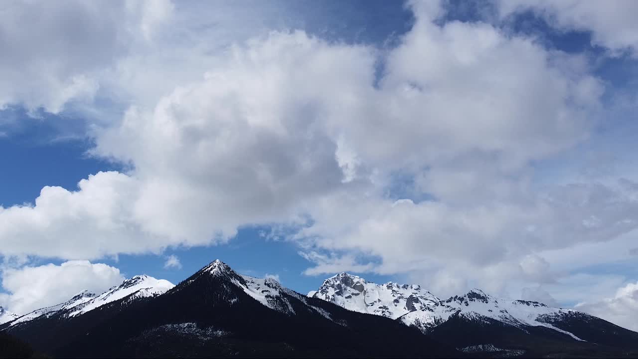 史诗般的空中拍摄，白色的山峰，蓝色的天空和缓慢移动的云视频素材