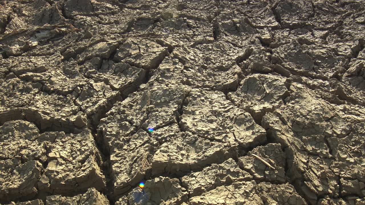 特写破碎的地面由干旱的夏季炎热干燥的土壤在变暖危机中显示全球缺水的星球和气候变化视频素材