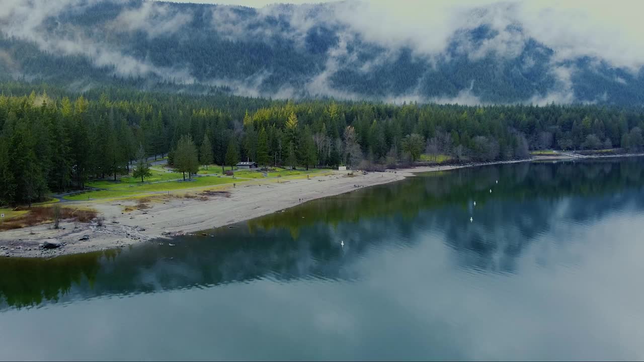 鸟瞰图的海滩上的湖小桌子做烧烤和包围的山视频素材